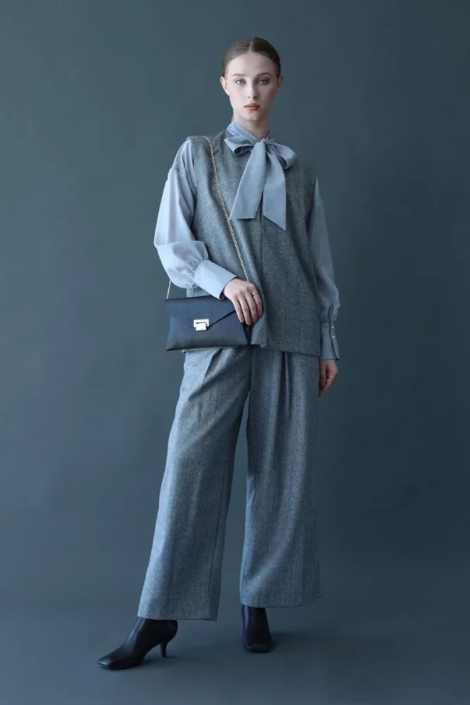 Full-length shot of a model in a grey vest and wide trousers